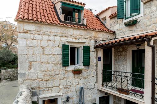 an old stone building with green shutters and a balcony at ToMaDi Residence in Split
