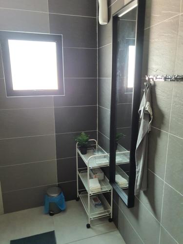 La salle de bains est pourvue d'un miroir, d'une étagère et d'une fenêtre. dans l'établissement Bali Paradise Cottage, à Kampung Tumbuk Pantai