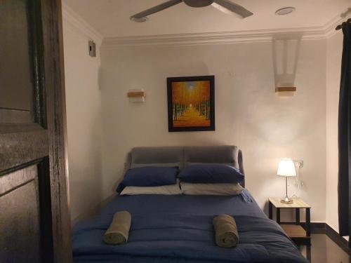 - un lit avec des oreillers bleus dans une chambre dans l'établissement Bali Paradise Cottage, à Kampung Tumbuk Pantai