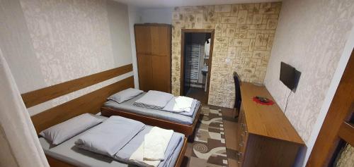 Pensiunea Raiul Munților في Sebiş: غرفة صغيرة بسريرين وطاولة