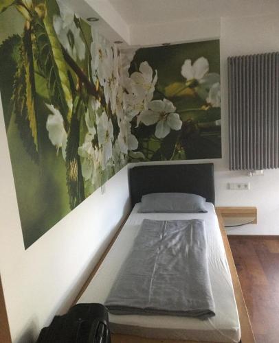 a bed in a room with a painting on the wall at Gasthof Kirschtraum in Sontra