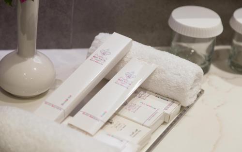a bathroom counter with towels and a pile of toiletries at Comfort Hotel Jeddah King Road in Jeddah