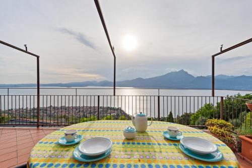 - une table avec des assiettes et des tasses sur le balcon dans l'établissement Terrazza Torri del Benaco, à Torri del Benaco