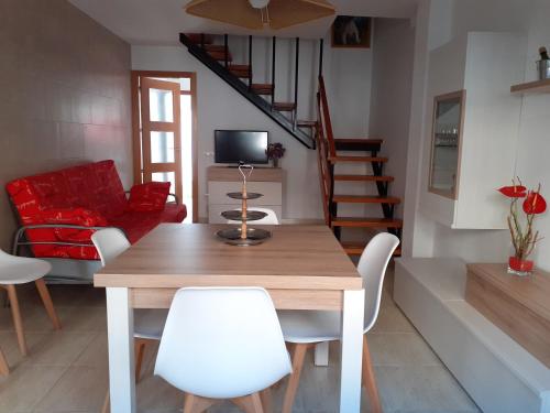 sala de estar con mesa de madera y sillas blancas en Apartamento Nuria Los Abanicos, en Peñíscola