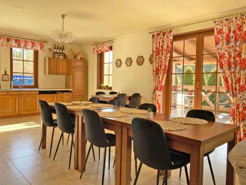 a dining room with tables and chairs and a kitchen at Brzozowy Dworek - Winnica Lipowiec in Lipowiec