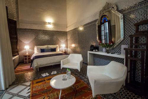 a bedroom with a bed and a table and chairs at Riad Braya in Fès