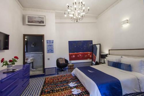 a hotel room with a bed and a chandelier at Riad Braya in Fès