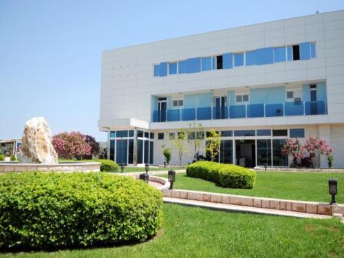 a large white building with bushes in front of it at Hotel Panorama in Šibenik