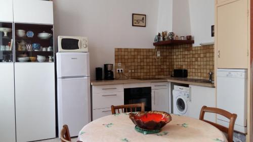 uma cozinha com uma mesa e um frigorífico branco em 35 ter rue du Docteur Marçon em Bandol