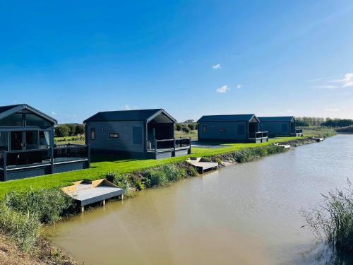 a row of houses on the side of a river at Chapel Fields Holiday Park in Chapel Saint Leonards