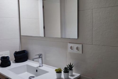y baño con lavabo blanco y espejo. en Feel Welcome Barcelona Smart flat, en Cornellà de Llobregat