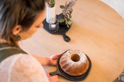 a woman sitting at a table with a donut at Apartment Schichlreit in Annaberg im Lammertal