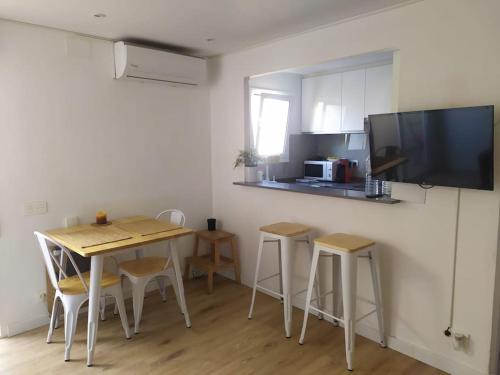 cocina con mesa y sillas y cocina con TV en Feel Welcome Barcelona Smart flat, en Cornellà de Llobregat