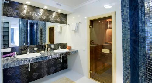 un bagno con due lavandini e un grande specchio di Pearl Mini-Hotel a Odessa