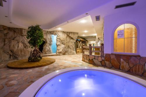 ein großes Bad mit einer Badewanne mit Pflanze in der Unterkunft Hotel Soreghes Gran Chalet in Campitello di Fassa