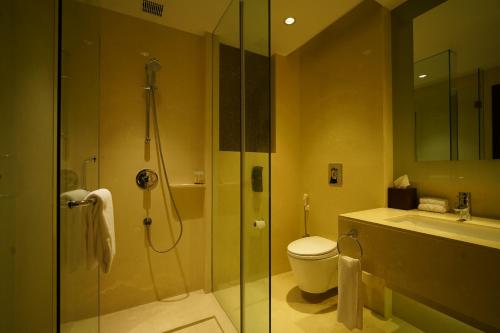 a bathroom with a shower and a toilet and a sink at Crowne Plaza Kochi by IHG in Cochin