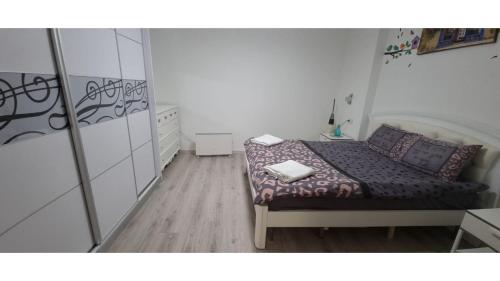 a small bedroom with a bed and a mirror at Garden apartments. in Mas'ade
