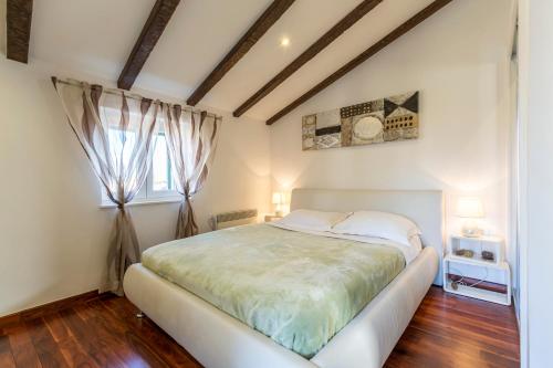 a bedroom with a white bed and a window at ToMaDi Residence in Split