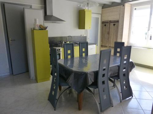 une cuisine avec une table et des chaises dans une cuisine dans l'établissement LE BON ABRI JURA, à Marigny