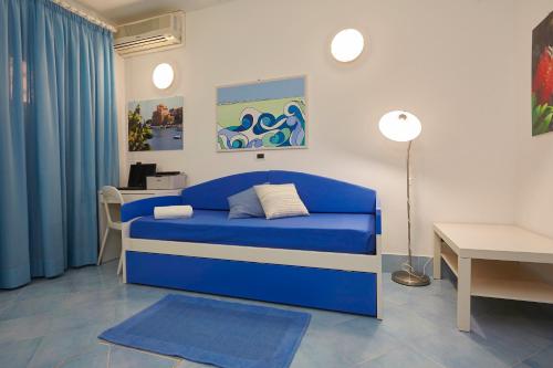 a blue couch in a room with a table at Appartamenti Rosa Dei Venti in Trapani