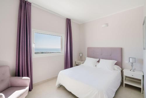 a bedroom with a white bed and a window at Boutique Hotel Mamabels in Mojácar