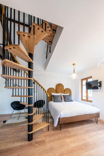 une chambre avec un lit et un escalier en colimaçon dans l'établissement L'elegant - Appart'Hotel Le Gatsby, à Saint-Quentin