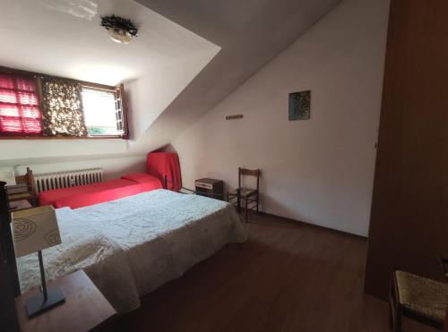 um quarto com uma cama vermelha e uma janela em BUONAVACANZA IN MONTAGNA em Limone Piemonte