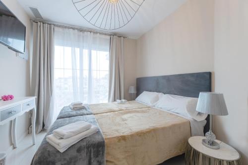 a bedroom with a large bed and a large window at Residencia Deportiva RozaRossa in Estepona