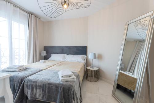 a white bedroom with a bed and a mirror at Residencia Deportiva RozaRossa in Estepona