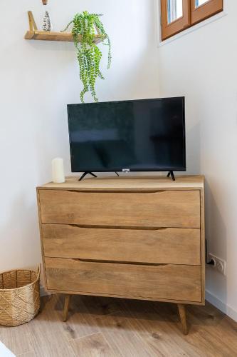 un téléviseur à écran plat posé sur une commode dans l'établissement Le Nid - Appart'Hotel Le Gatsby, à Saint-Quentin