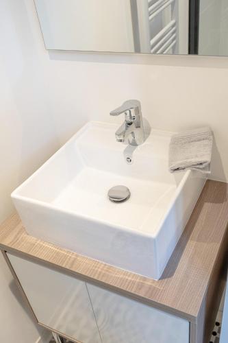 um lavatório branco num balcão na casa de banho em Le Nid - Appart'Hotel Le Gatsby em Saint-Quentin