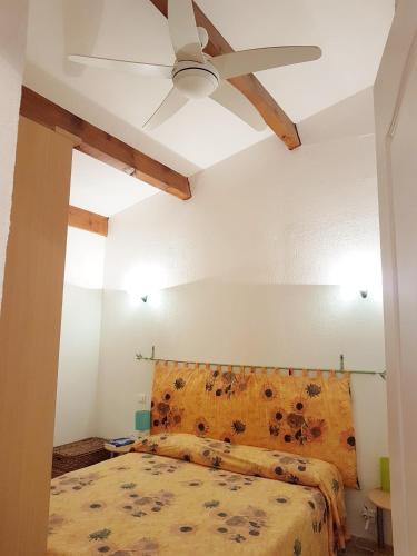 une chambre avec un lit avec un ventilateur de plafond dans l'établissement FAVONA, à Conca