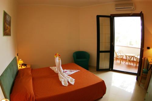 a room with a bed with a towel on it at Hotel Village Eden in Capo Vaticano