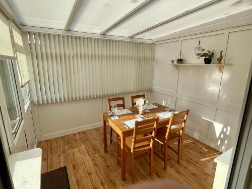 a dining room with a wooden table and chairs at Cherry Tree Lodge in Norwich