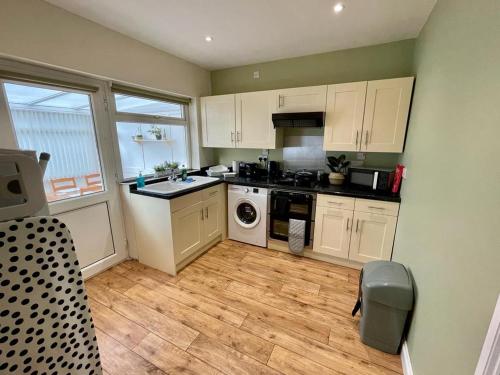 a kitchen with white cabinets and a stove top oven at Cherry Tree Lodge in Norwich