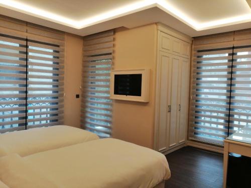 a bedroom with two beds and a flat screen tv at Opatija Hotel in Istanbul