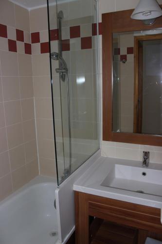 a bathroom with a tub and a sink and a shower at Temples du Soleil Nazca Appartements VTI in Val Thorens