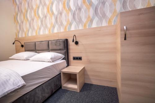 a bedroom with a bed with a wooden head board at Zlatna Kruna in Banja Luka
