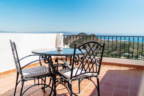 a table and chairs on a balcony with a view of the ocean at Boutique Hotel Mamabels in Mojácar