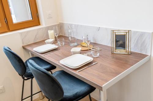 - une table à manger avec des chaises et un miroir dans l'établissement L'avant-gardiste - Appart'Hotel Le Gatsby, à Saint-Quentin