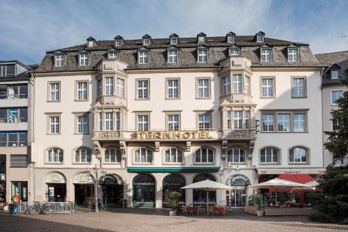 a large white building with a sign on it at ACHAT Sternhotel Bonn in Bonn