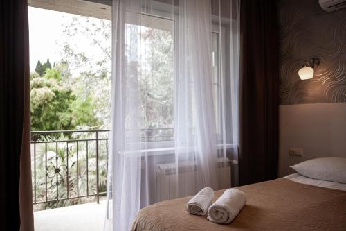 a bedroom with a bed and a large window at Guest house On Griboedova Street in Sochi