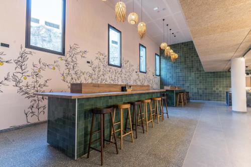 a bar in a restaurant with stools and a wall at MEININGER Marseille Centre la Joliette in Marseille
