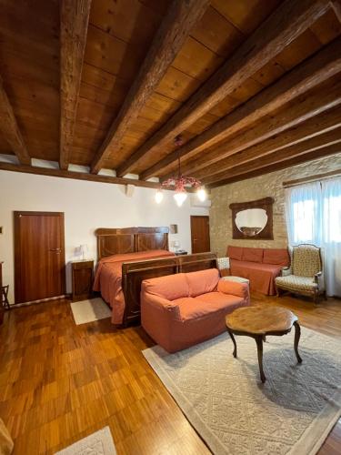 a bedroom with a bed and a couch and a table at Agriturismo Le Vescovane in Longare
