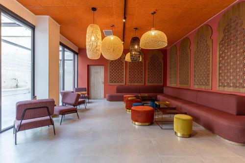 a waiting room with red furniture and colorful chairs at MEININGER Marseille Centre la Joliette in Marseille