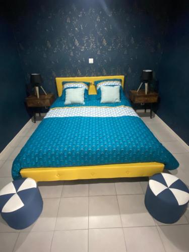 1 cama azul y amarilla en una habitación con 2 mesas en Gîte de la Prévosserie, en Rinxent