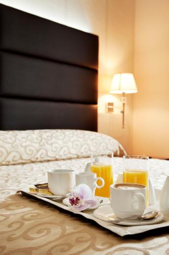 a tray with breakfast foods and drinks on a bed at S Hotel in San Giovanni Teatino