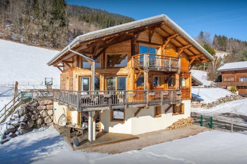 a log home in the snow at Chalet Levant Blanc - OVO Network in Seytroux