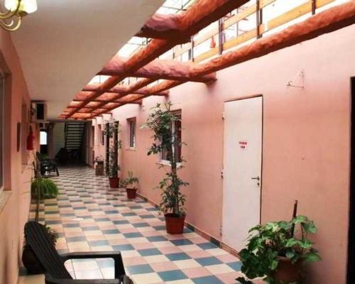 a room with a checkered floor with potted plants at Hotel Itavera in Puerto Iguazú