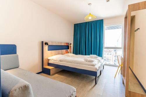 a bedroom with two beds and a window at MEININGER Marseille Centre la Joliette in Marseille